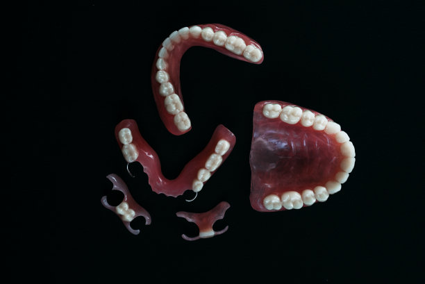 黑色背景上的假牙。假牙的特写。牙科是概念摄影。假牙科。假牙。假肢。塑料假牙的特写。黑色背景上的牙齿图片下载