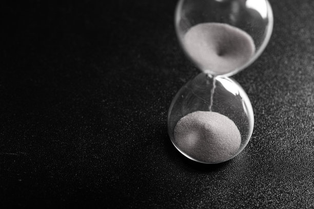 沙子通过一个沙漏测量旅行时间倒计时到最后期限，黑白照片图片下载