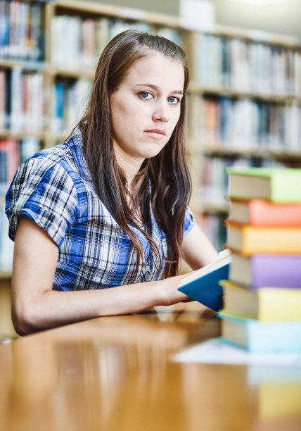 在大学图书馆里，严肃的女学生抬起头来图片下载