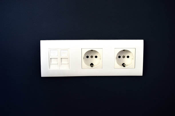 蓝色墙上挂着白色电源插座，还有互联网接口图片下载