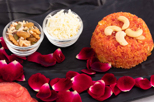 美味的Gajar Ka Halwa或胡萝卜布丁Gajrela Halua制成的磨碎的胡萝卜，牛奶奶油，Meetha Mava糖，Desi Ghee Khoya Mawa Badam Kismis和Pista。在托盘与花卉装饰图片下载