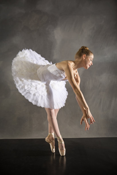 穿着白色芭蕾舞裙的芭蕾舞女演员，在康涅狄格州的演播室里跳舞。素材图片
