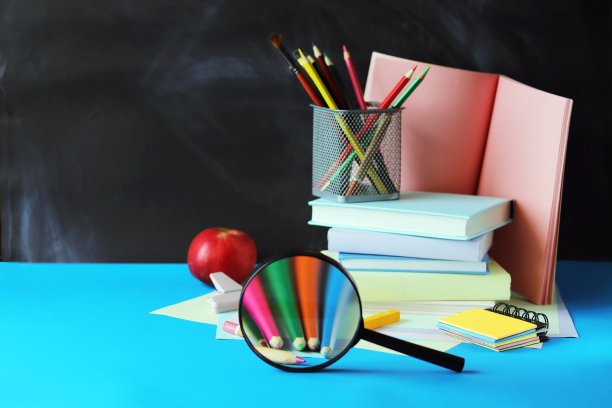 回到学校，书本，放大镜，苹果，笔记本和黑板上的铅笔图片下载