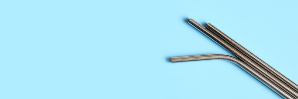 可重复使用的金属不锈钢吸管，蓝色背景。空间的文本。横幅图片下载