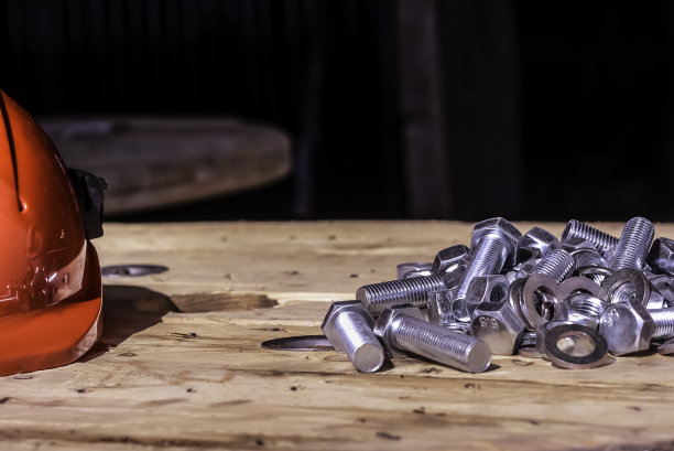 木制背景上的金属螺栓和螺母图片下载