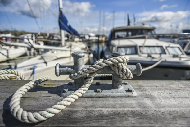 在一个阳光明媚的日子里，旧港口停泊在夏日码头的背景中。图片下载