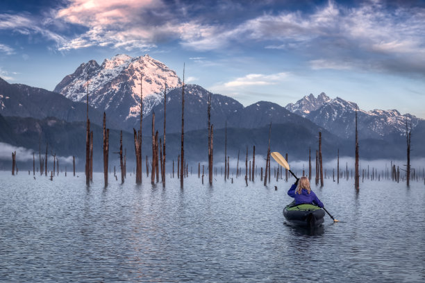 爱冒险的女孩在美丽的湖中乘坐充气皮划艇图片下载
