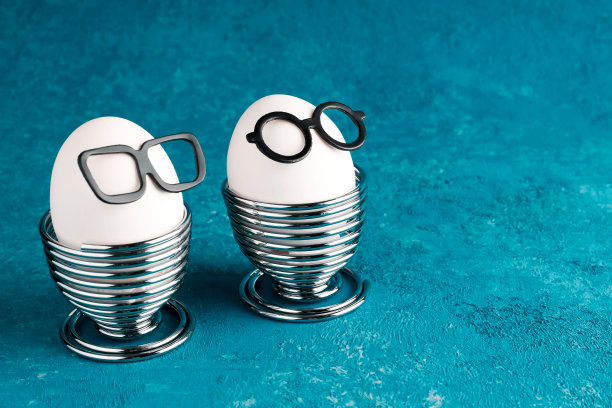 复活节创意节日概念。绿松石背景下的白色鸡蛋。眼镜和早餐。副本的空间。有趣的食物。图片下载