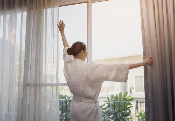 旅行者美丽的亚洲女人微笑着看那边呆在酒店房间的门附近图片下载