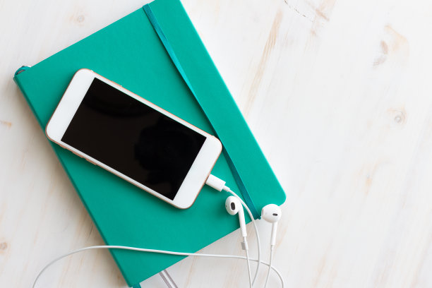 智能手机与耳机蓝绿色的书图片下载
