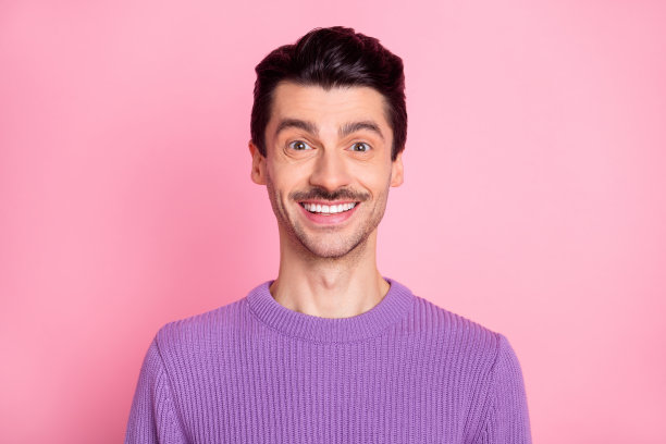 照片的年轻开朗的男人快乐积极的牙齿微笑陶瓷口腔孤立在粉红色的背景图片下载