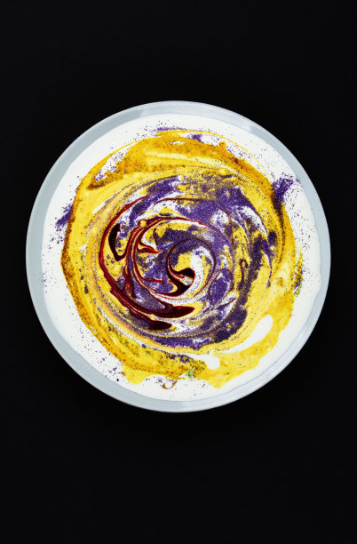 深色背景上有黄色油漆和圆形污迹的盘子。抽象艺术。寻找艺术作品的素材。图片下载