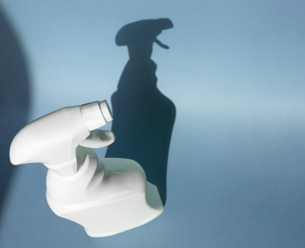白色喷雾瓶和坚硬的阴影在蓝色的背景图片下载