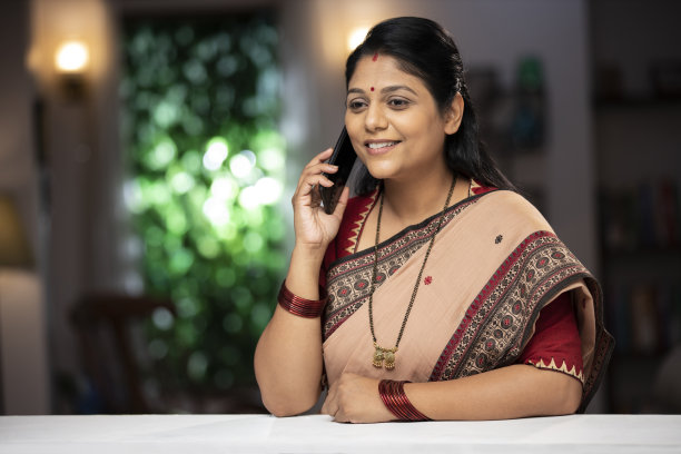 一个中年妇女站在窗户和阳台附近打电话的照片:库存照片图片下载