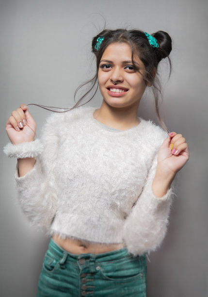 快乐的时髦的年轻女子的肖像看着相机与牙齿的微笑。图片下载