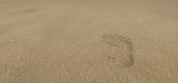 在海滩上的脚印的特写，有选择的焦点在脚印上。图片下载
