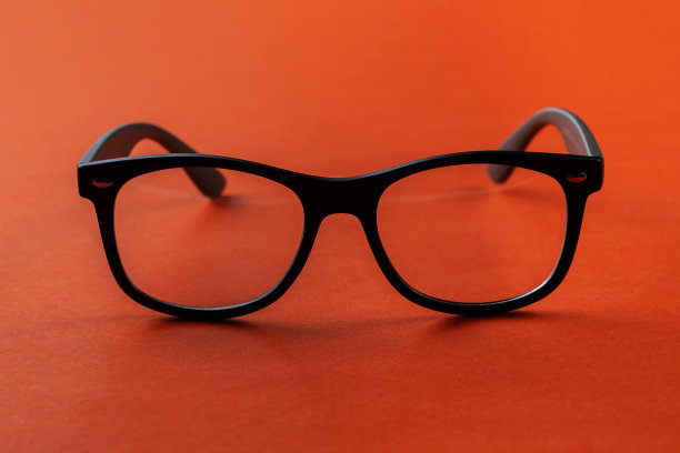橙色背景的眼镜，近视或老花。视力矫正。图片下载