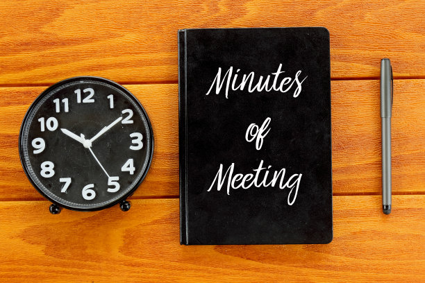 俯视图的时钟，笔和笔记本写会议记录在木制的背景。商业和财务概念。图片下载