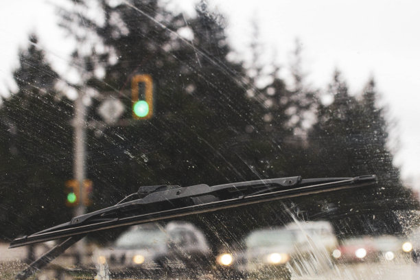 从汽车内部透过肮脏的挡风玻璃看雨时，在恶劣的气象条件下的道路上，前后背景都被散景效果模糊了图片下载