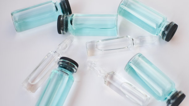 小瓶疫苗，白色背景上有透明蓝色液体的玻璃安瓿俯视图，全球接种概念图片下载