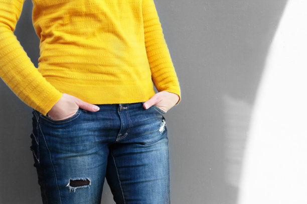 一个穿着亮黄色毛衣和蓝色牛仔裤的女孩图片下载