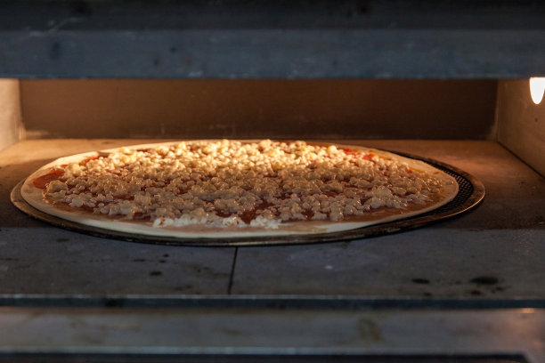 又薄又好吃的披萨是在烤箱里烤的。在披萨店里做披萨。图片下载