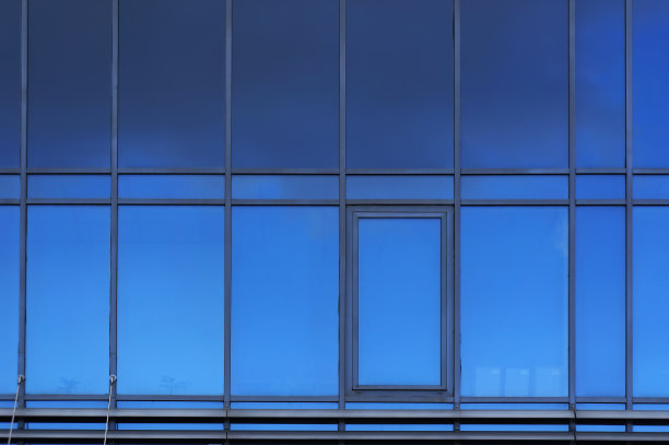 现代建筑立面上的窗户。建筑的蓝色背景。图片下载