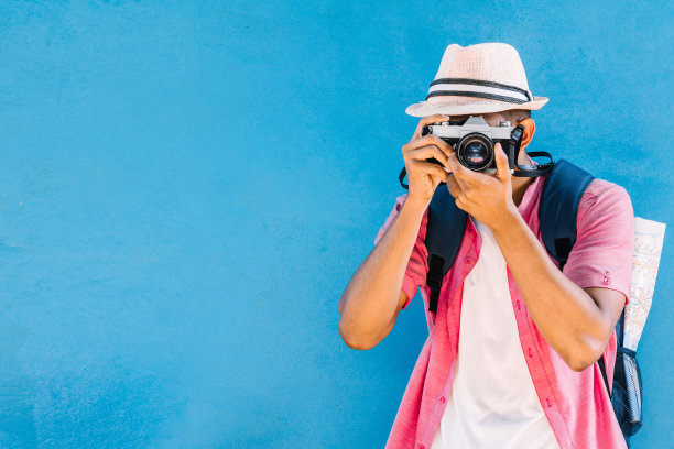 男性旅行者拿着相机拍照。图片下载