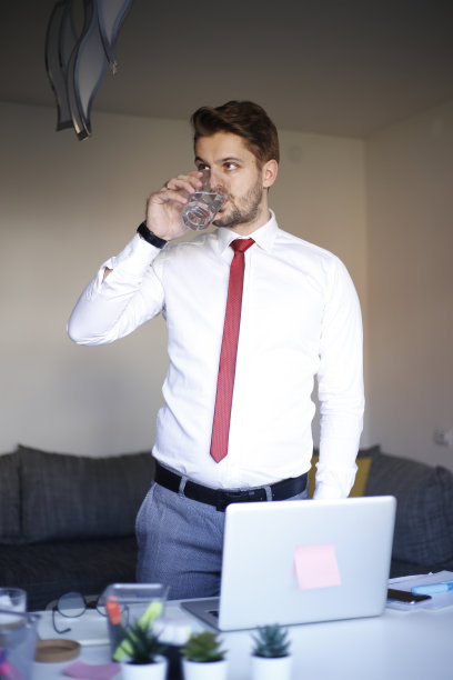 在工作中喝水的商人。库存图片图片下载