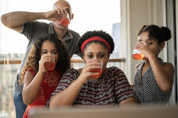 快乐的家庭在家里视频通话时喝果汁图片下载