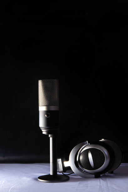专业冷凝器麦克风和耳机，白色表面和黑色背景，低调肖像，选择性聚焦。图片下载