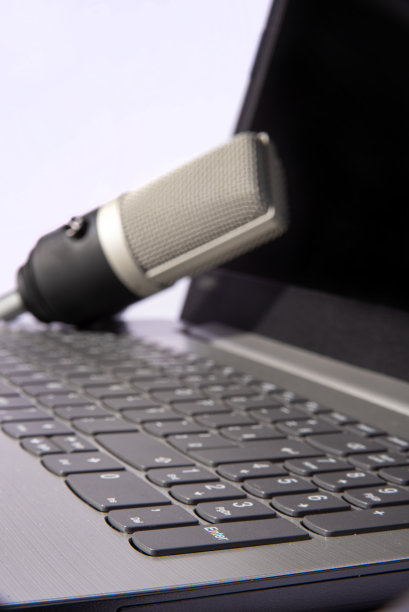 家庭作业，专业电容麦克风和电脑对光背景，选择性聚焦。图片下载