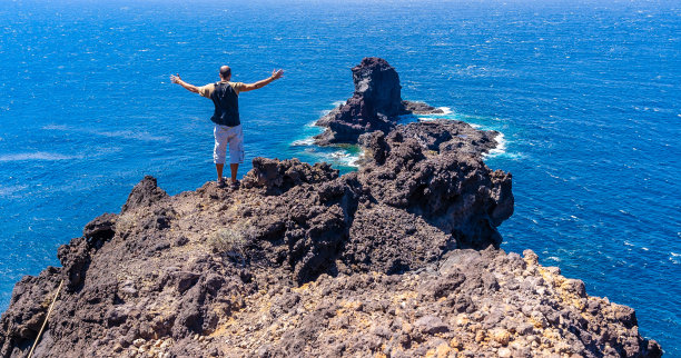 加那利群岛拉帕尔马岛北部，一名年轻的游客正沿着悬崖小路往布贾伦的黑沙滩下坡。西班牙图片下载