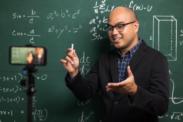 印度年轻教师男子通过智能手机进行在线视频会议直播。亚洲数学教师在线授课，供学生在线学习。图片下载