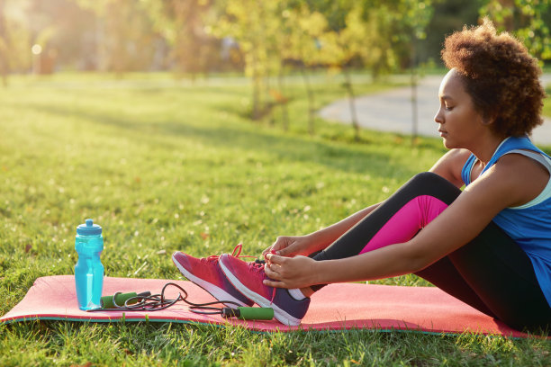 可爱的小女孩在户外穿运动服系鞋带图片下载