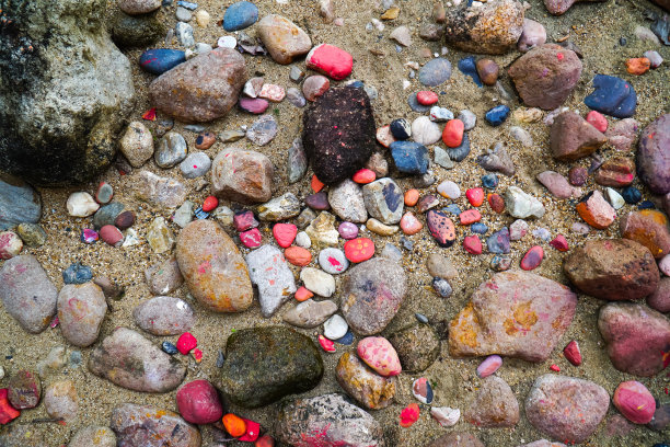 在地板背景上涂上彩色的石头。地上的卵石画着五颜六色图片下载
