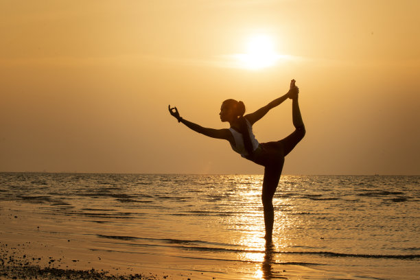 一个女人在海滩上做瑜伽的剪影素材图片
