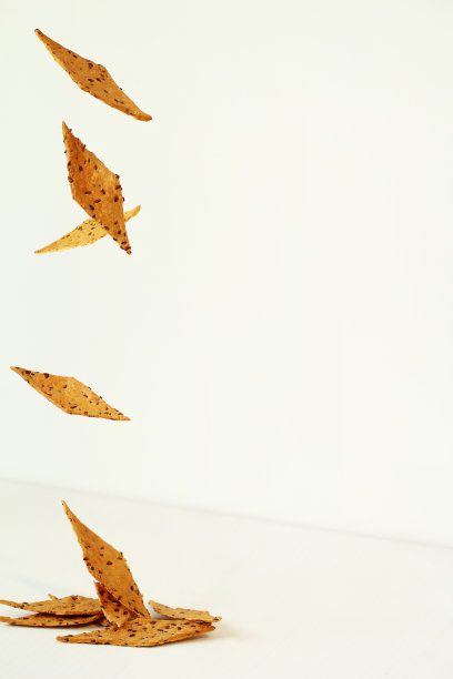 亚麻籽像秋叶一样飘落在白色的背景上图片下载