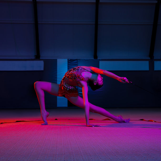 优雅的白人女子体操运动员在霓虹灯的彩色背景下孤立图片下载