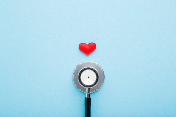 听诊器的红色心在浅蓝色的桌子的背景。柔和的颜色。医生工具心跳监听。医疗保健的概念。特写镜头。自顶向下的观点。图片下载