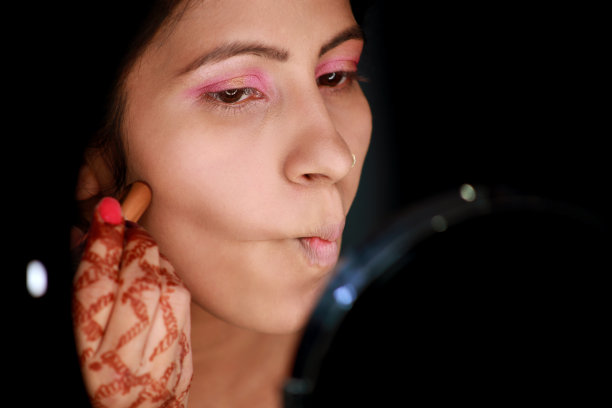 女性使用液体粉底在脸上图片下载