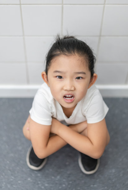 疲惫的小女孩蹲在地上图片下载