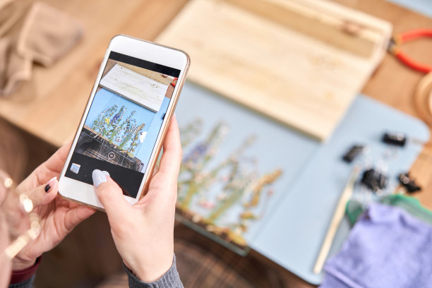 一个女人在为博客和社交网络拍照。大师班创建框架与植物标本室在蒂凡尼技术在彩色玻璃。图片下载