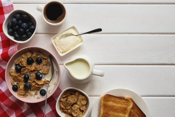 健康早餐:全麦片加牛奶，蓝莓，一杯咖啡和烤面包，放在有复印空间的木桌上。俯视图，平放图片下载