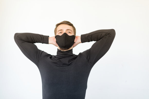 特写英俊的白人男子与可重复使用的黑色面具。概念与复印空间在办公室靠近窗户图片下载