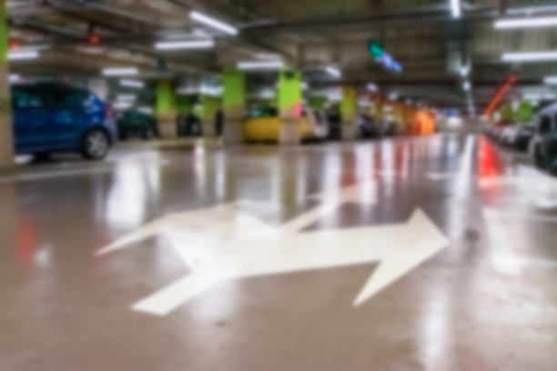 停车位模糊。空道路沥青背景软焦点。车位在城市地下车库。隐藏的地下停车场。图片下载