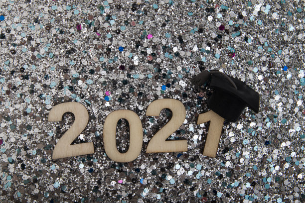 毕业2021木数字2021戴着研究生帽在闪亮的背景俯视图图片下载