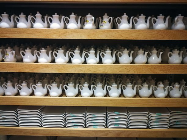 超市货架上出售的一堆白色盘子和牛奶罐。销售的概念图片下载