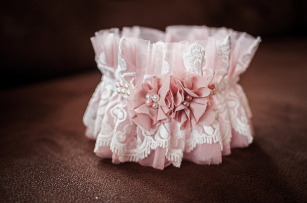 桃色的吊袜带躺在木桌上图片下载