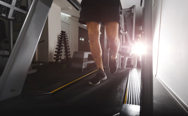 一个人在健身房跑步机上跑步是为了锻炼，健身和健康的生活方式图片下载